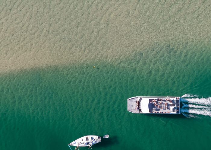 Boats cruising along the Coolongolook River at Wallis Lake, Forster