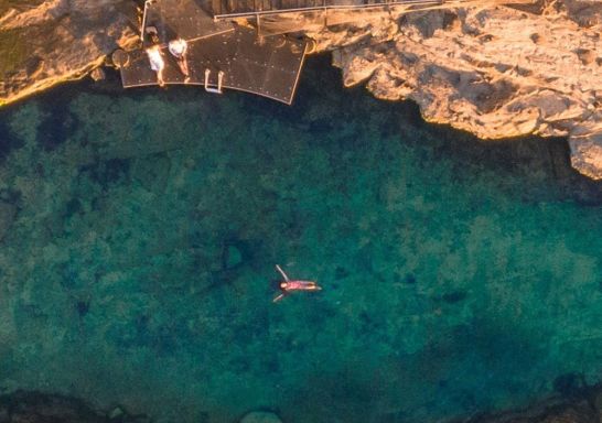 Aerial view of man swimming at the Bogey Hole, Newcastle
